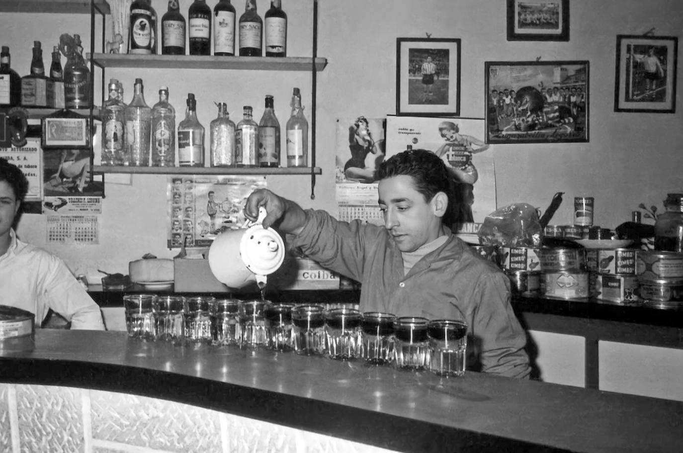 Camarero sirviendo vino en vasos de txikito.