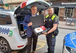 El concejal de Seguridad Ciudadana, Ángel Madrazo, muestra junto a un agente uno de los nuevos equipos desfibriladores de la Policía Local.