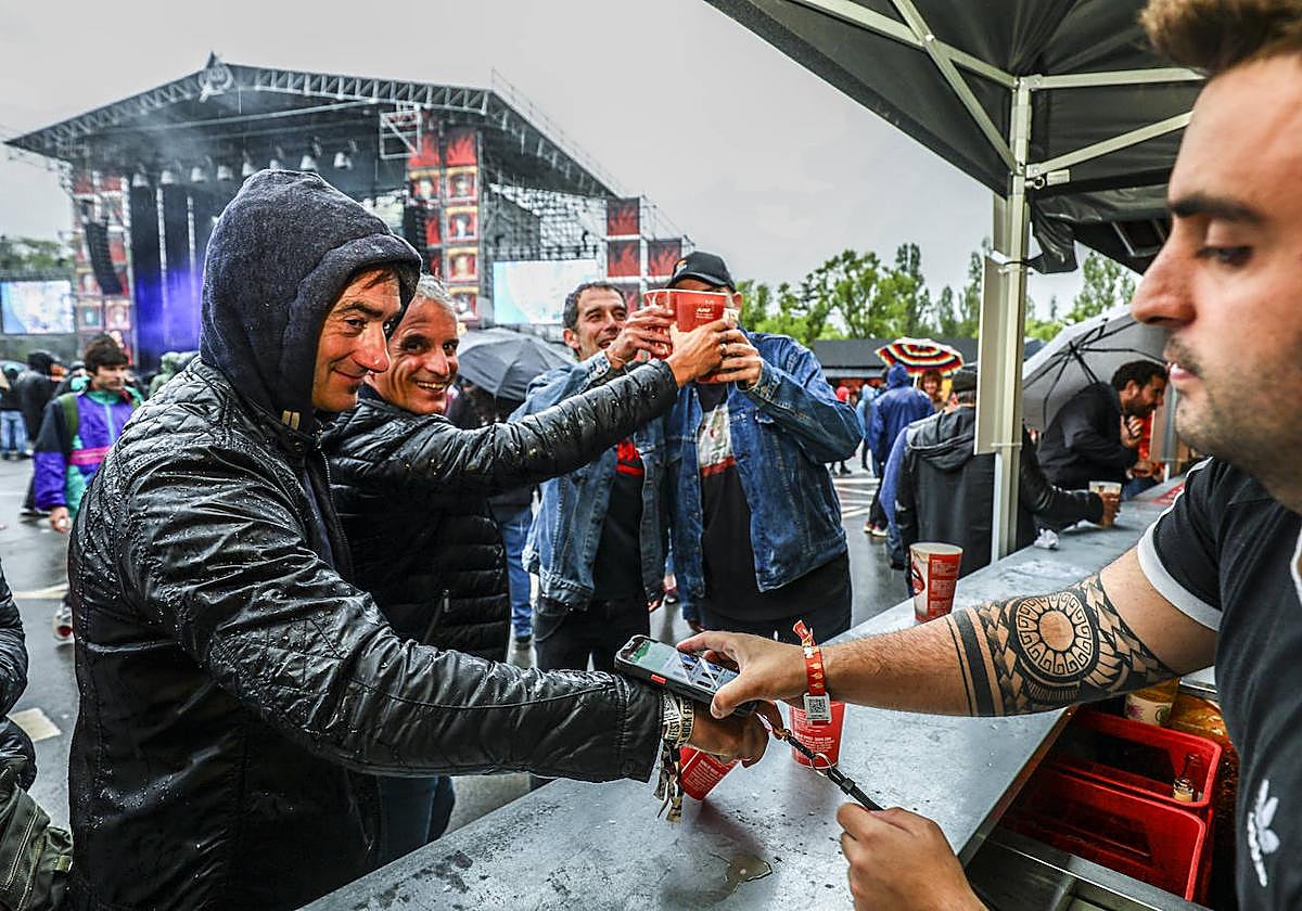 Uno de los 200 camareros que atienden las barras del festival cobran la consumición de un festivalero.