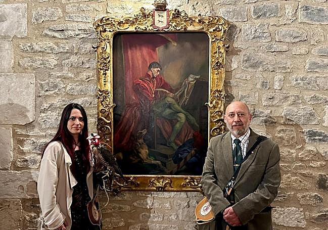 Los cetreros Rebeca Rego y Adolfo Ruiz sostienen a Vittoria, una hembra de halcón peregrino junto a un cuadro del Canciller Ayala de Sáenz de Tejada, en la Casa del Cordón.