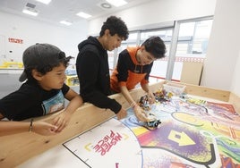 Un monitor y dos alumnos prueban un robot en las colonias de la Esperanza.