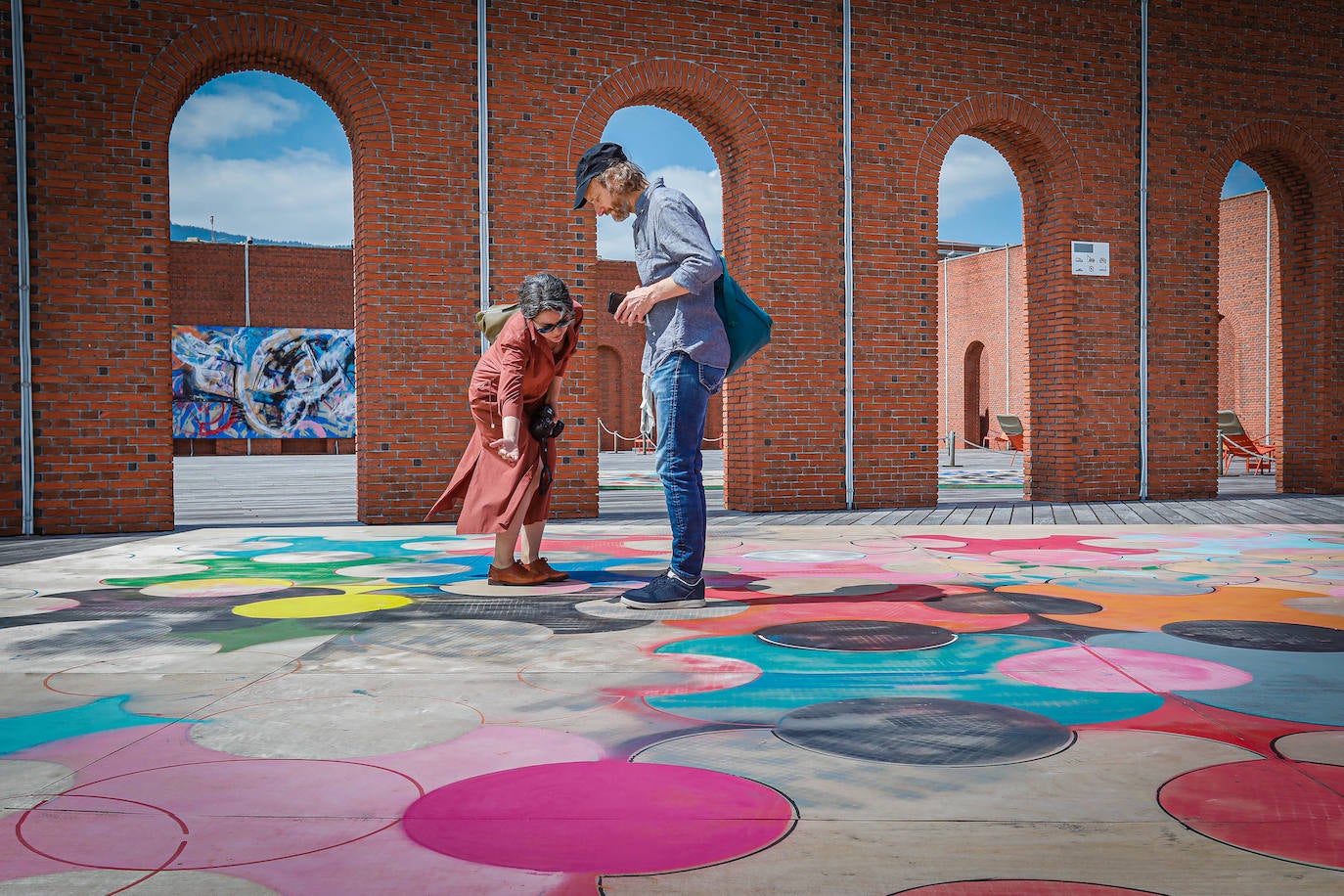 Dos visitantes caminan sobre uno de los suelos del artista.