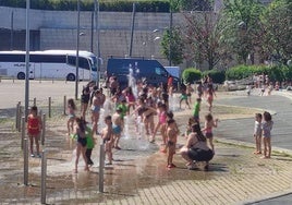 Varios niños se refrescan este viernes en los chorros de agua del Guggenheim Bilbao.