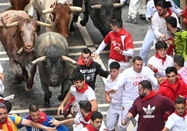 Uno de los miembros de la kuadrilla con la camiseta en honor a César García escapa de los toros.