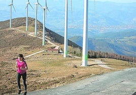 Una joven hace deporte junto al parque eólico del monte Oiz.