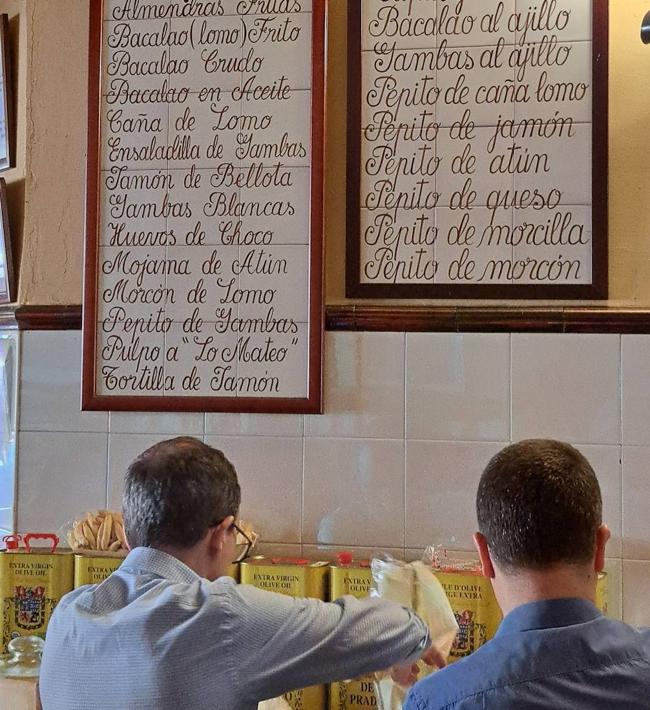 Roberto y Raúl junto a los carteles de raciones.