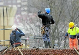 Empleados de la construcción trabajan en la obra de un edificio en una localidad vizcaína.