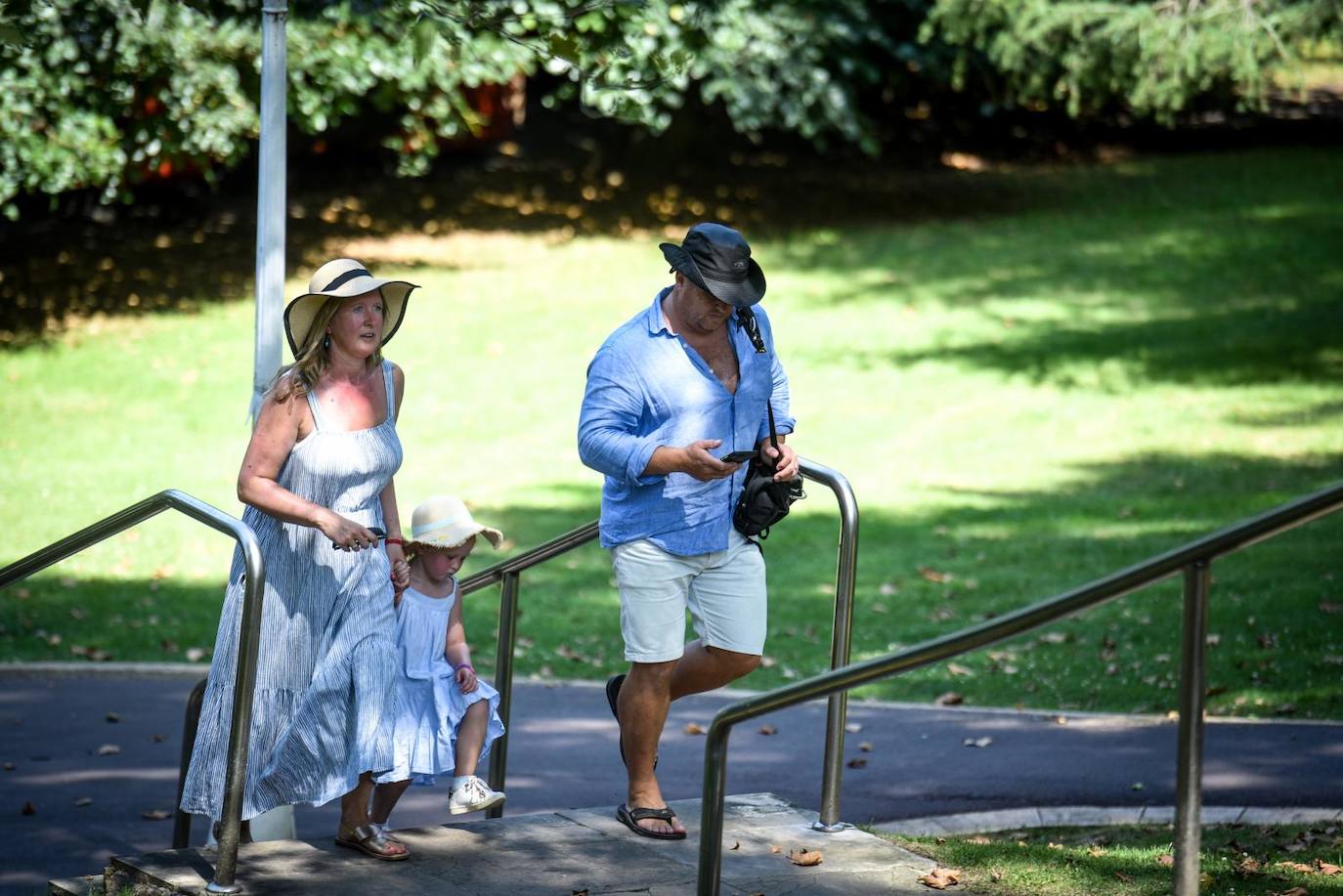 Turistas se protegen del sol con gorros y paseando por la sombra en Bilbao