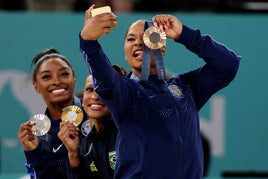 Jordan Chiles fotografiándose con la medalla de bronce junto a Biles y Andrade