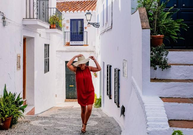 Una mujer pasea por las típicas calles de Frigiliana.