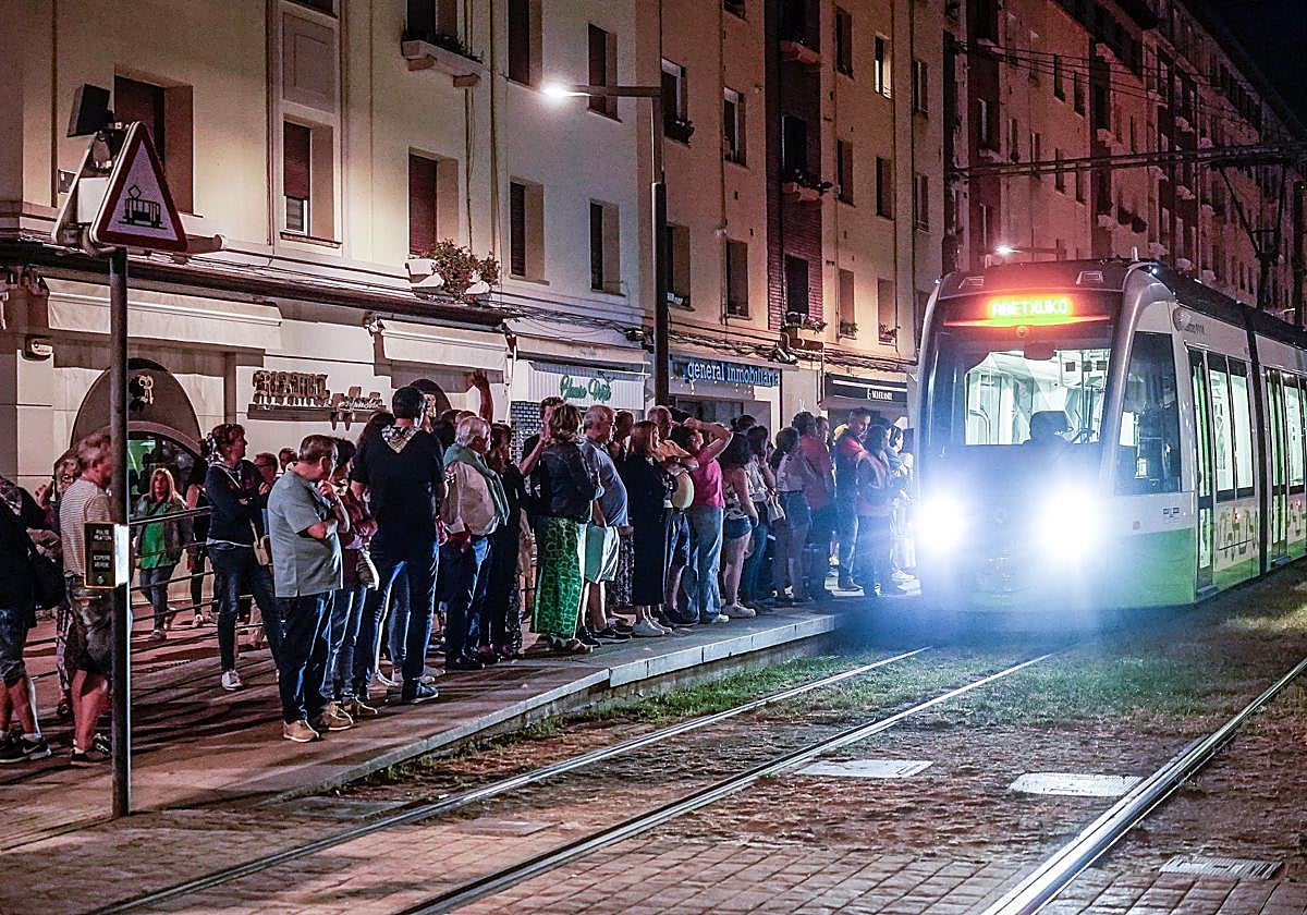 Numerosos ciudadanos aguardan la llegada del tranvía durante una de las noches de fiestas de Vitoria.