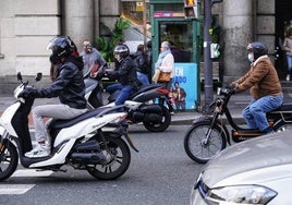 Conductores en moto circulando por el centro de Bilbao.