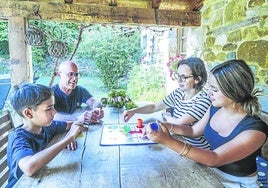 La familia Carbonell-Carrión juega en el porche de la casa Guikuri al parchis.