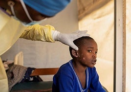Un sanitario atiende a un niño infectado en el Congo.