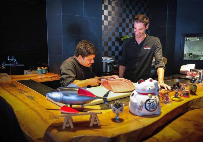 Lomana en la barra de sushi de Kuma (Ercilla, 8) junto a Kishor Pathak, cocinero nepalí. Encima de la mesa de madera de nogal de Oquendo, regalos nipones de clientes y un atún rojo desmontable con todos los cortes del ronqueo y que Dani se ha traído de Tokio.