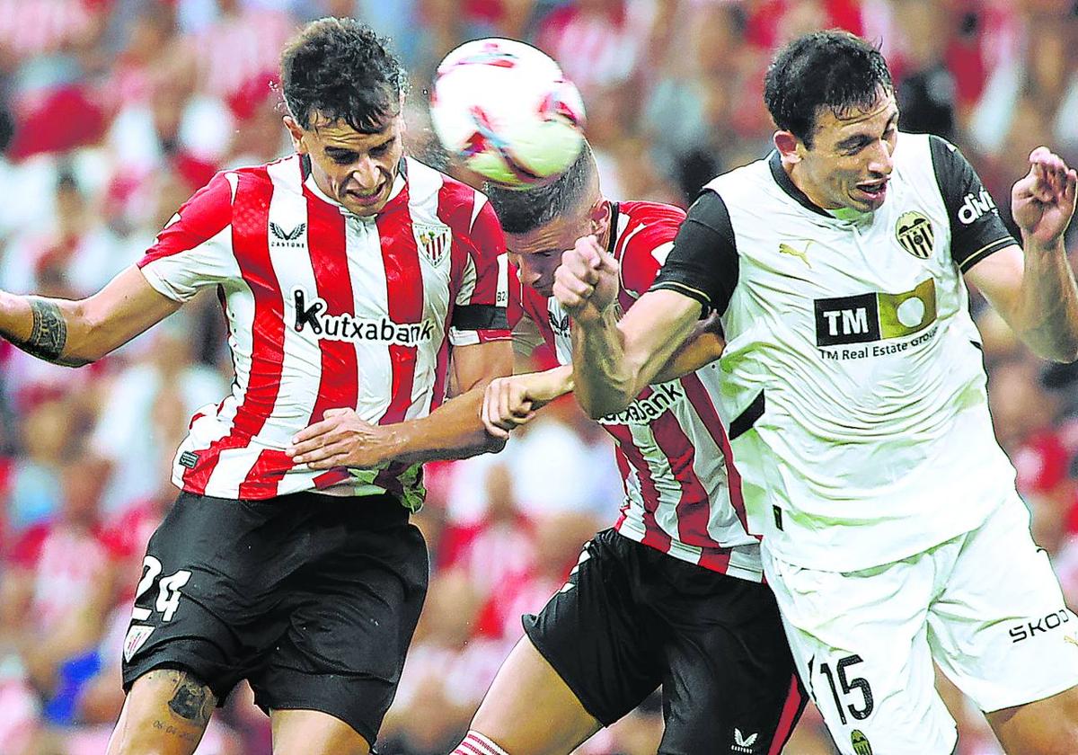 Prados remata de cabeza para marcar el gol ante el Valencia, en presencia de Guruzeta y el valencianista Tárrega.