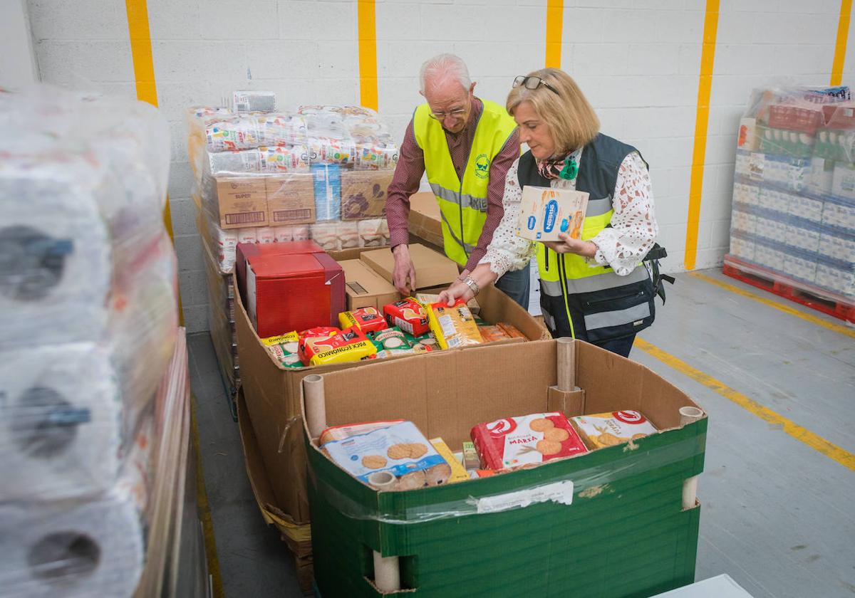 Daniel Fernández organiza junto con una voluntaria varios productos en almacén del Banco de Alimentos.