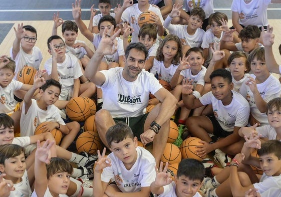 Jose Manuel Calderón y los niños de su campus hacen el gesto mítico del exjugador extremeño cuando anotaba un triple.