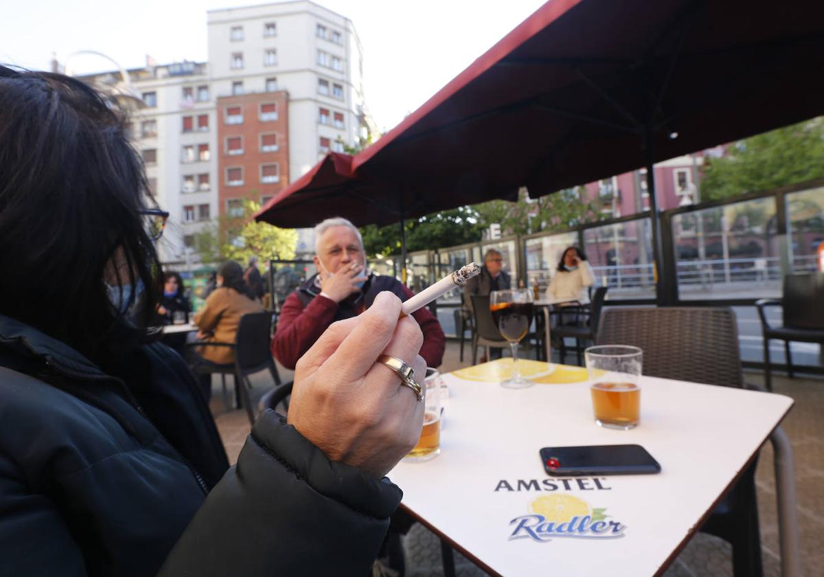 Clientes consumen alcohol y tabaco en la terraza de un establecimiento hostelero.