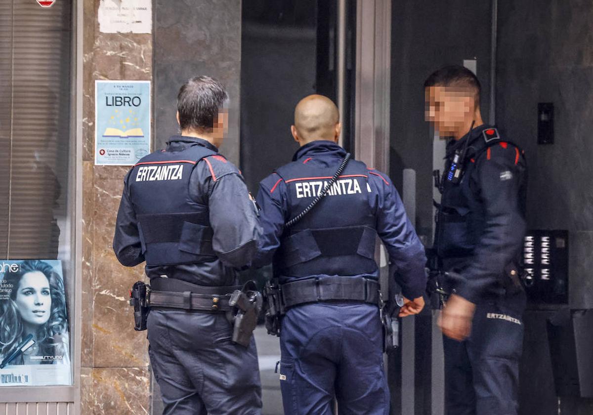 Agentes de la Ertzaintza aguardan en el portal del edificio de viviendas de la calle Cuba, en el barrio de El Pilar, donde se produjo el apuñalamiento.