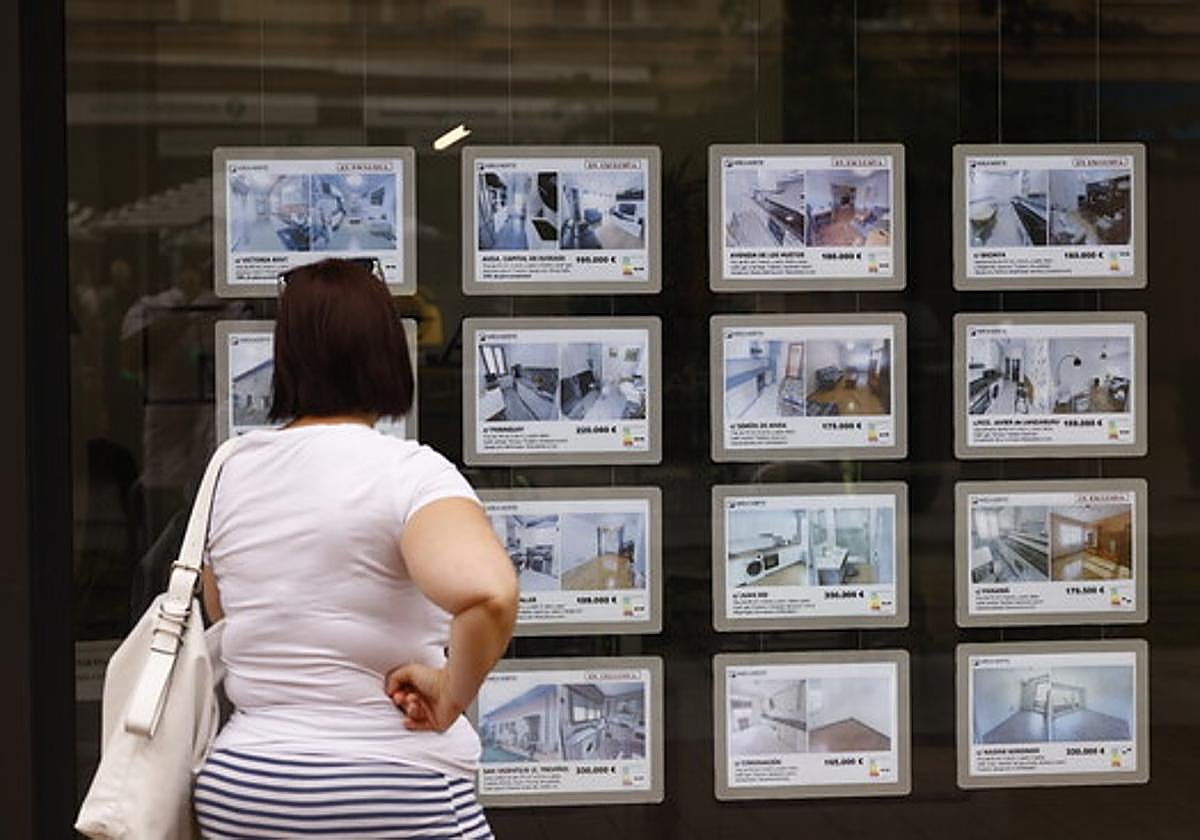Una mujer observa las viviendas en venta o alquiler.