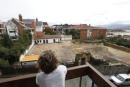 Una vecina contempla cómo ha quedado el solar en el que se derrbó un palacete para construir pisos de lujo.