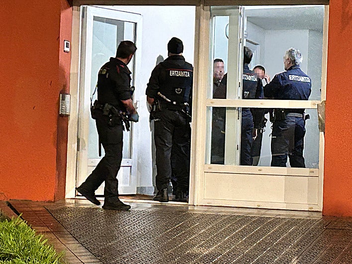 Agentes de la Ertzaintza en el portal del edificio donde tuvo lugar el asesinato.