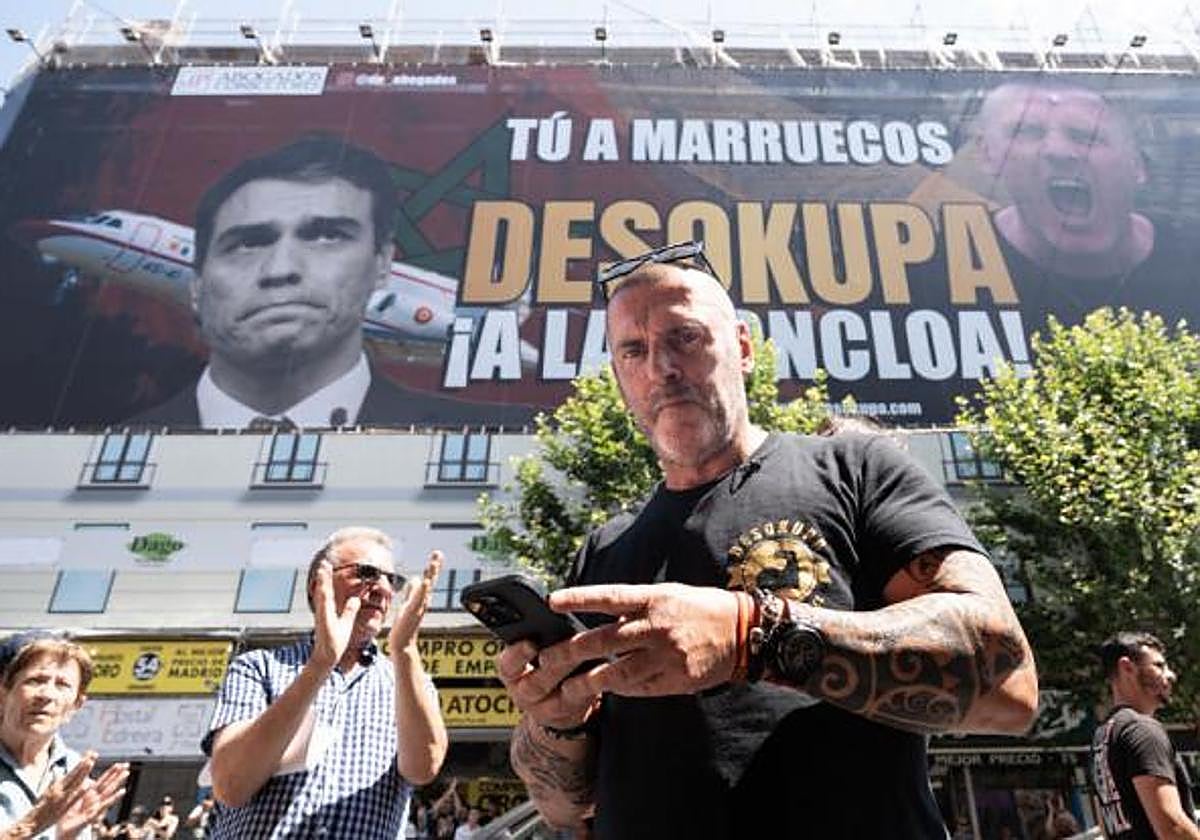 El líder de Desokupa, Dani Esteve, ante la lona colocada en Madrid contra el presidente del Gobierno.