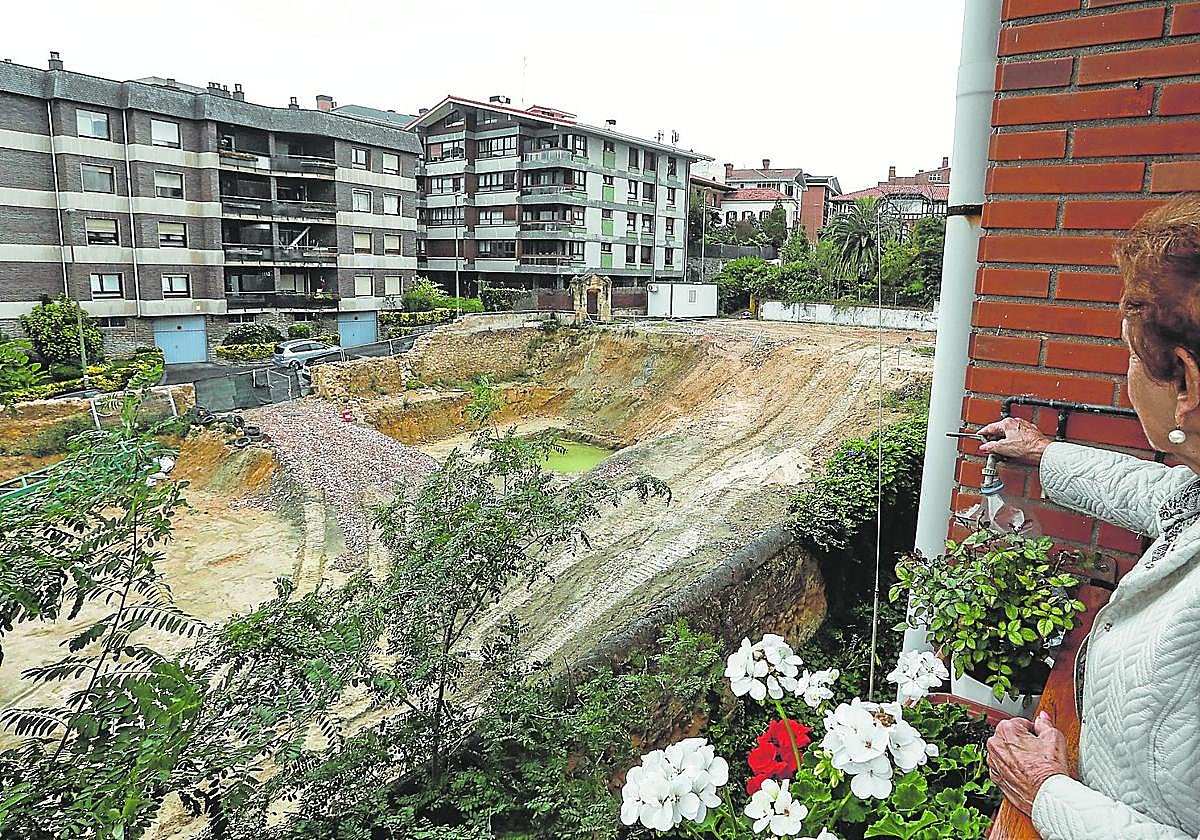 Una vecina observa el solar que ha dejado el derribo del palacete y en el que estaba previsto edificar 12 pisos de lujo.