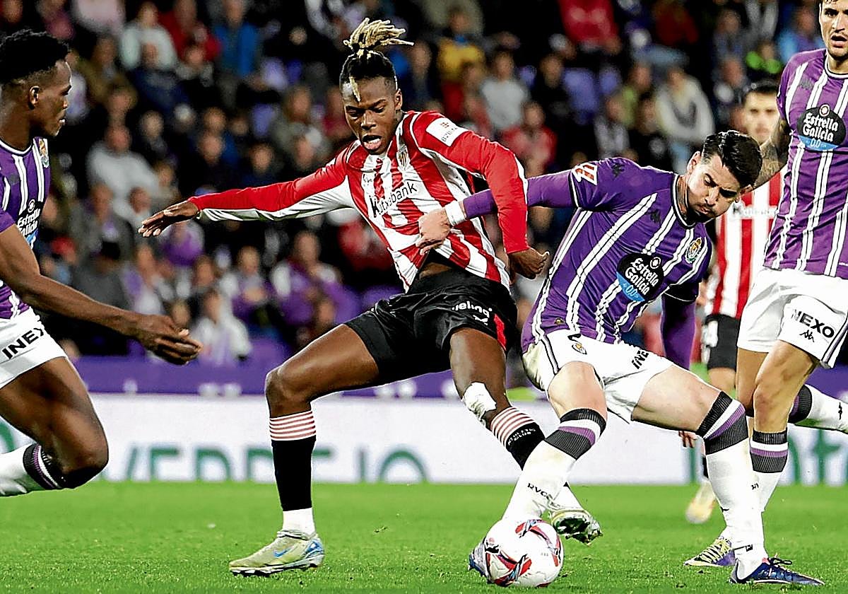 Nico Williams trata de recuperar una balón rodeado de jugadores del Valladolid..