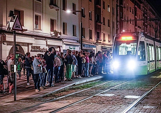 Usuarios esperan, de noche, el tranvía en la parada de Sancho el Sabio.