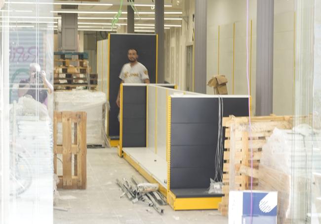 Trabajadores instalan las estanterías en el interior del nuevo local.