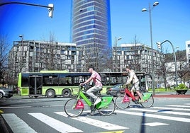 Bicicletas municipales y autobuses públicos frente a la torre Iberdrola, dentro de la ZBE.