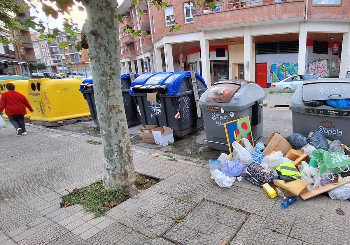 La basura se acumula en los contendores frente a la salida del metro de Sopela.