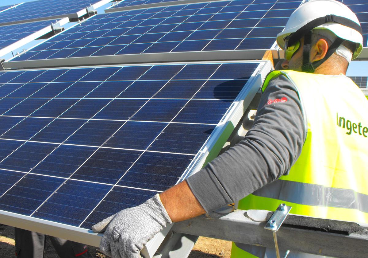 Un operario instala una placa fotovoltaica.