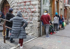 Varios ciudadanos hacen cola a las puertas de Berakah para recoger los 'tupers' de comida que reparte la ONG.