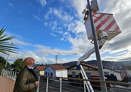 Operario instalando este jueves, junto al concejal Madrazo, uno de los sistemas de videovigilancia en Cadagua.