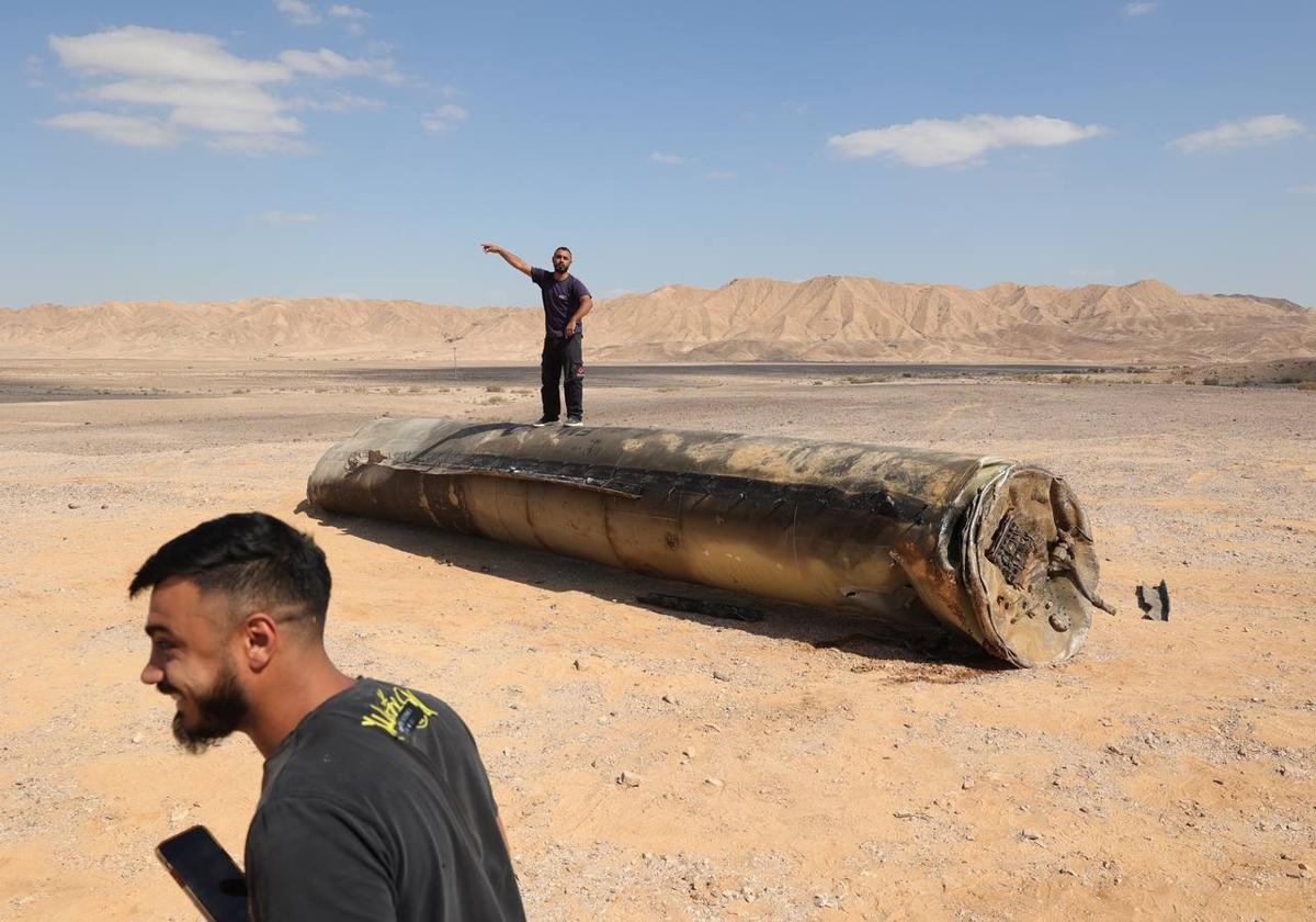 Beduinos israelíes observan de cerca los restos de un misil balistico lanzado por Irán en las afueras de la ciudad de Arad, al sur de Israel.