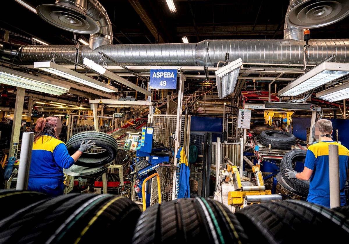 Trabajadores de Michelin Vitoria, junto a varios neumáticos terminados.