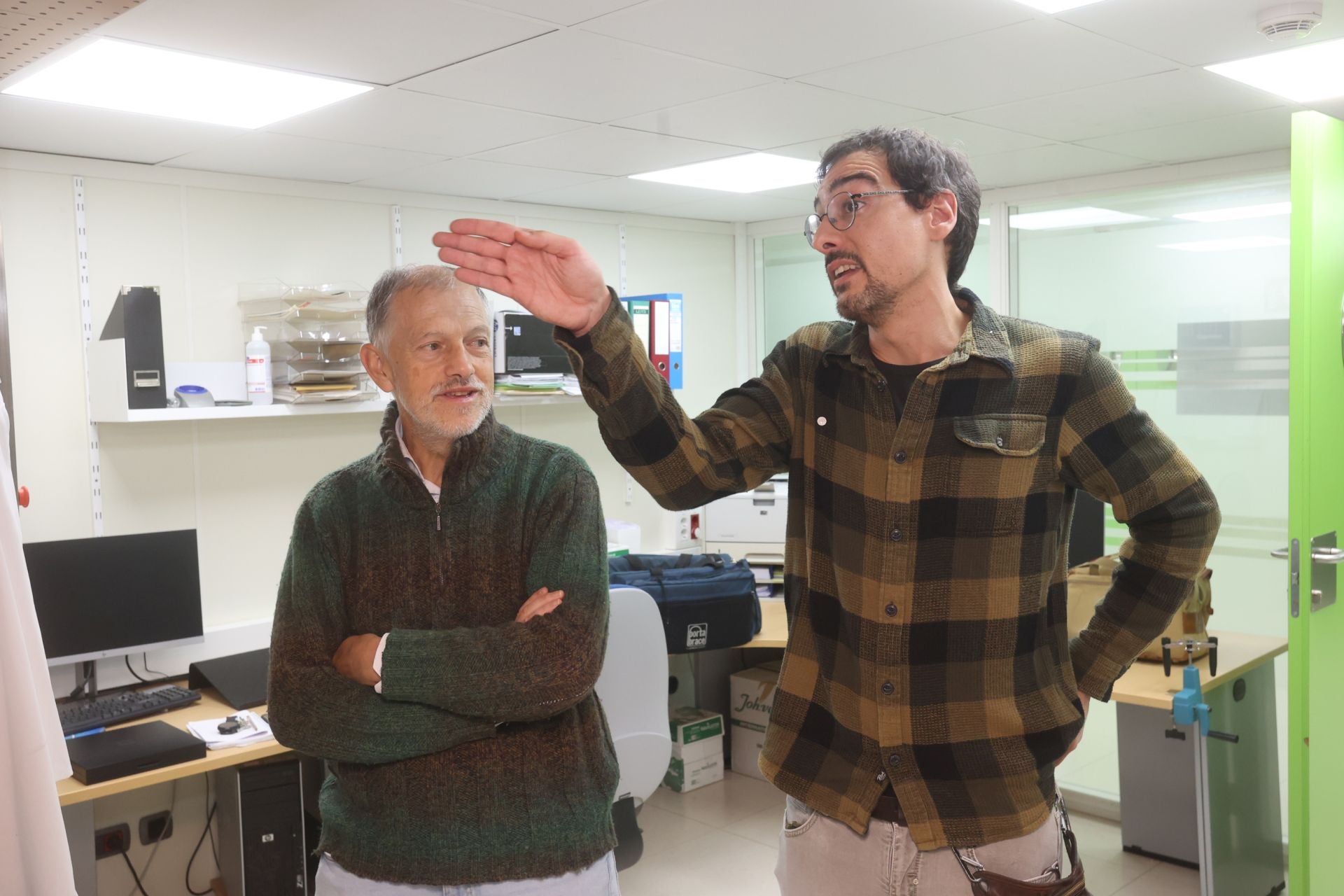 Pedro Ángel Fernández, a la izquierda, atiende las explicaciones de un científico del CIC Biogune.