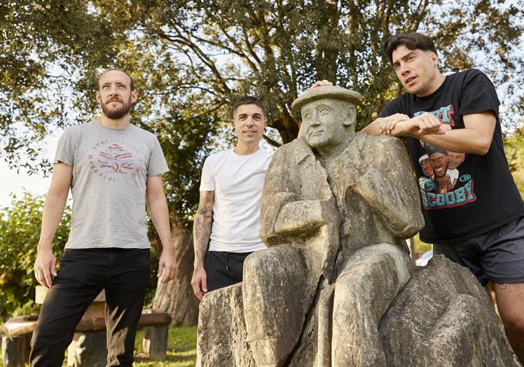 Jon Sola, Julen Baz y Eneko Axpe junto a la estatua de Julián Larrea, hendida por el rayo, que ha dado origen a su revolucionaria máquina de cocina, que asa carne en segundos.