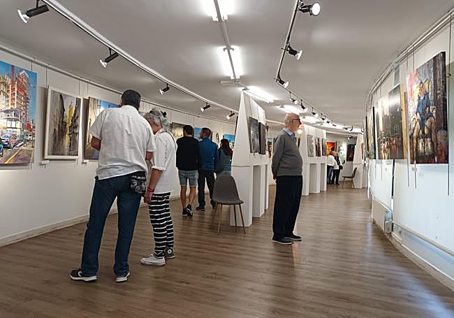 Los visitantes observando las obras artísticas del concurso en la sala de Ezkurdi.