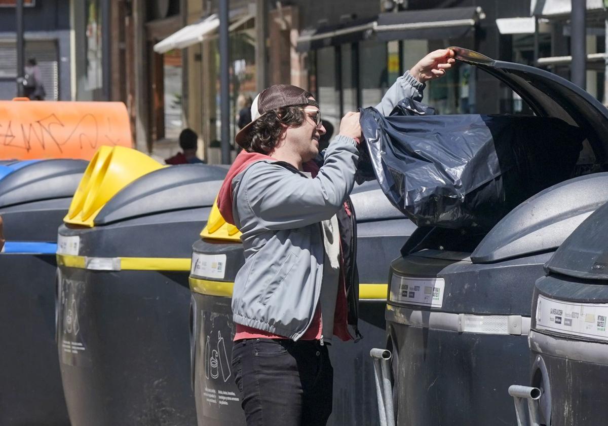 Un ciudadano deposita la basura en un contenedor en Vitoria.