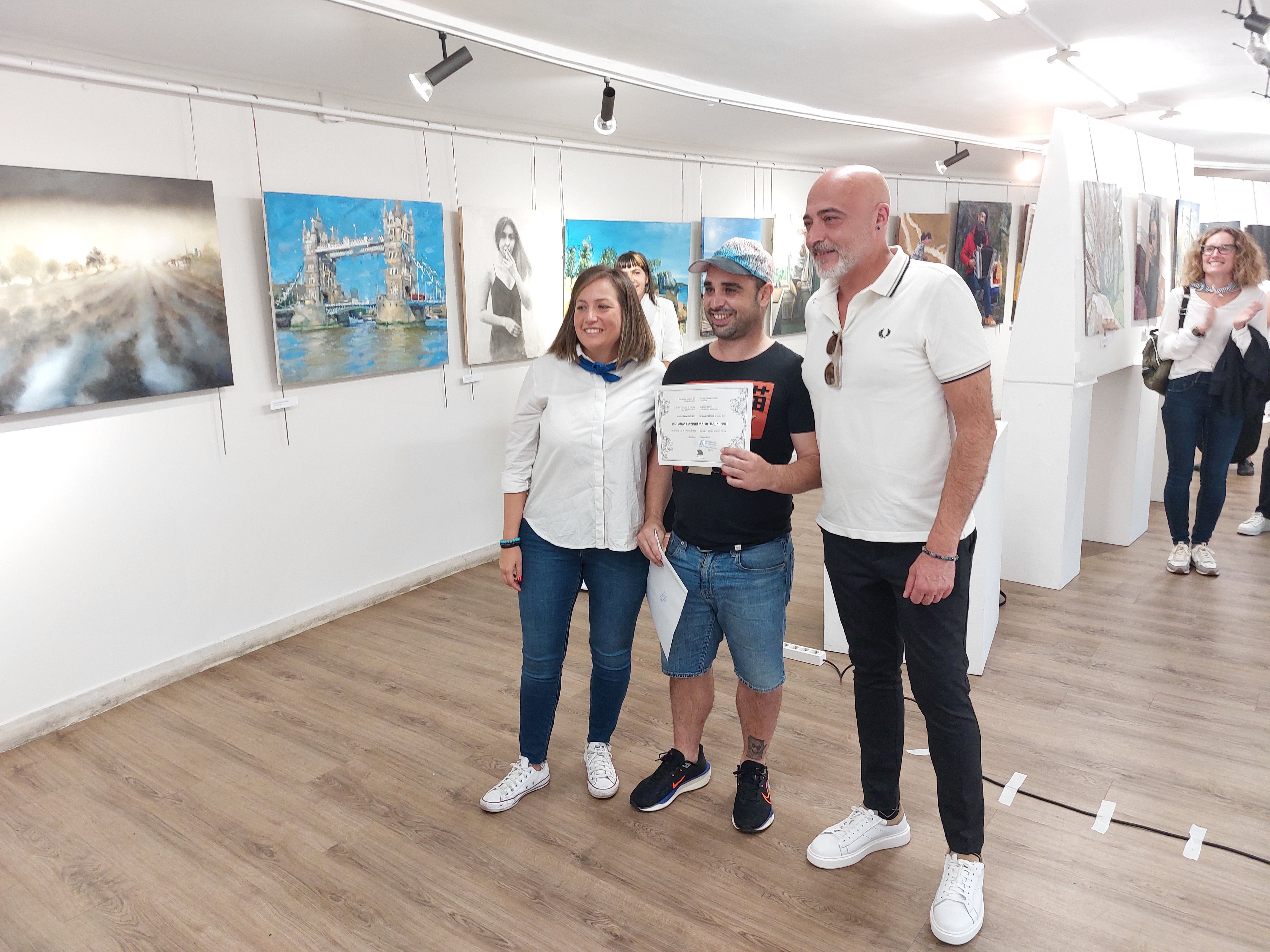 Imagen secundaria 2 - Foto de familia de los premiados y la primera, Azucena Fernández y el artista local, Aratz Azpiri.