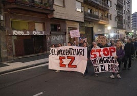 La manifestación de los vecinos pasa por una de las lonjas okupadas.