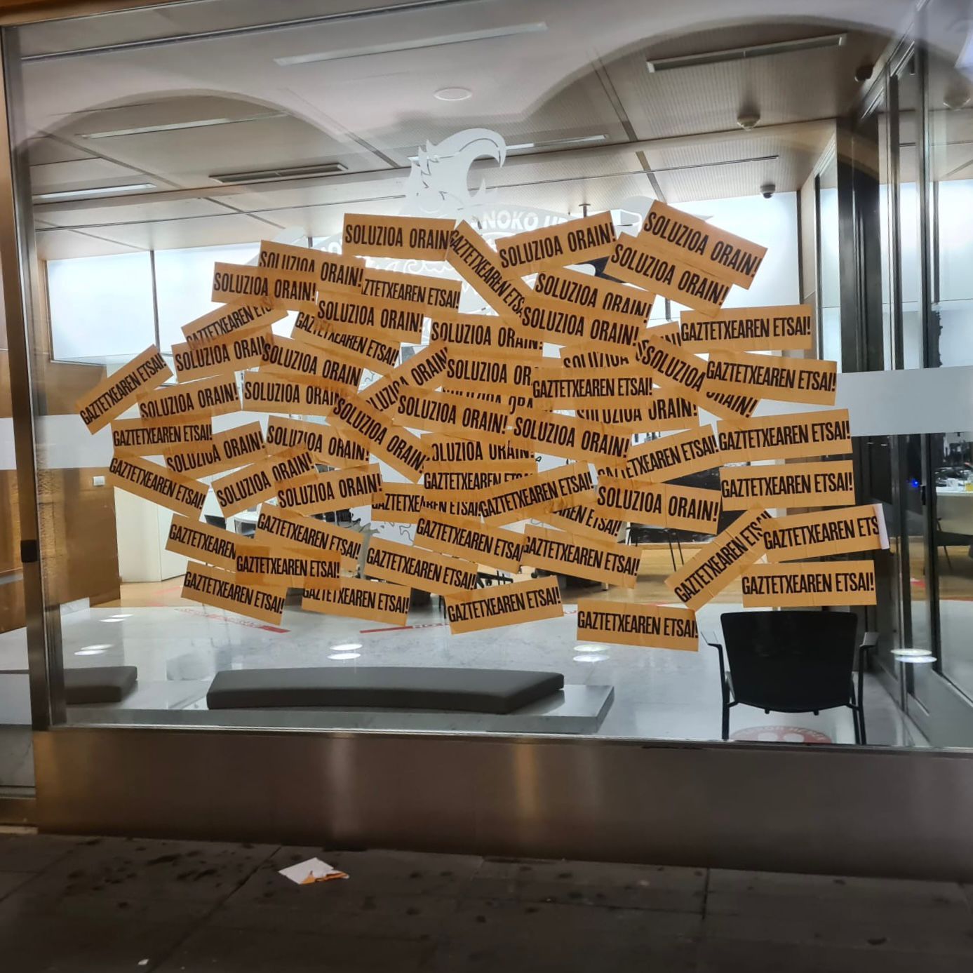 Imagen de las cristaleras del Ayuntamiento cubiertas de pegatinas.