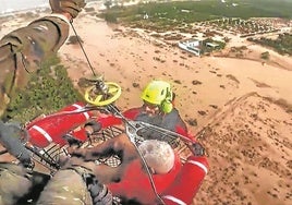 Un hombre es izado hacia el helicóptero.