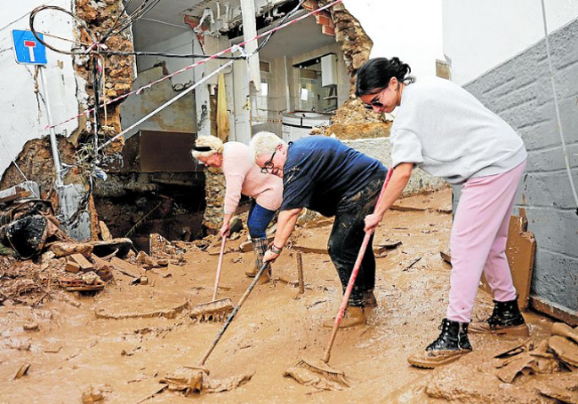 Tres mujeres ayudan en la calle.