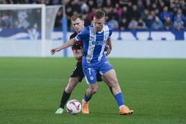 Carlos Vicente controla el balón ante la oposición de un rival.