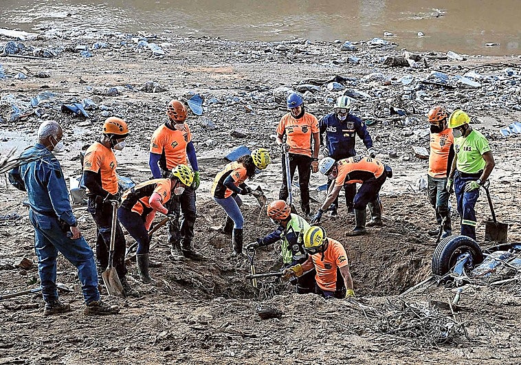 Momento de la recogida de un coche en la ribera de un río.